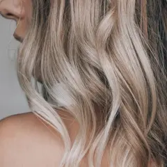 Falujące, blond włosy z pasemkami, które przypominają błyskawice na niebie.