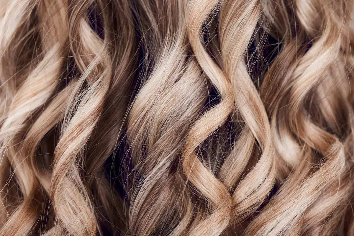 Falujące, blond włosy z subtelnymi refleksami, jak po zabiegu flamboyage.